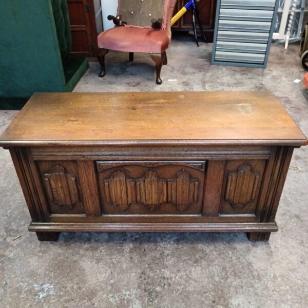 Vintage oak blanket box with carved details, ideal for storage.