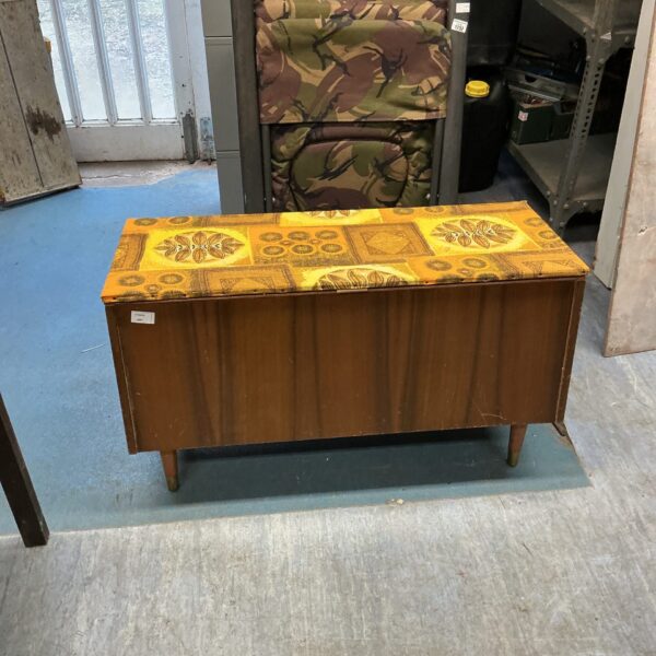 Vintage ottoman with geometric pattern and wooden legs.