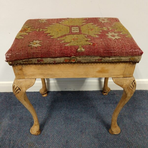 Vintage piano stool with patterned fabric seat and cabriole legs.