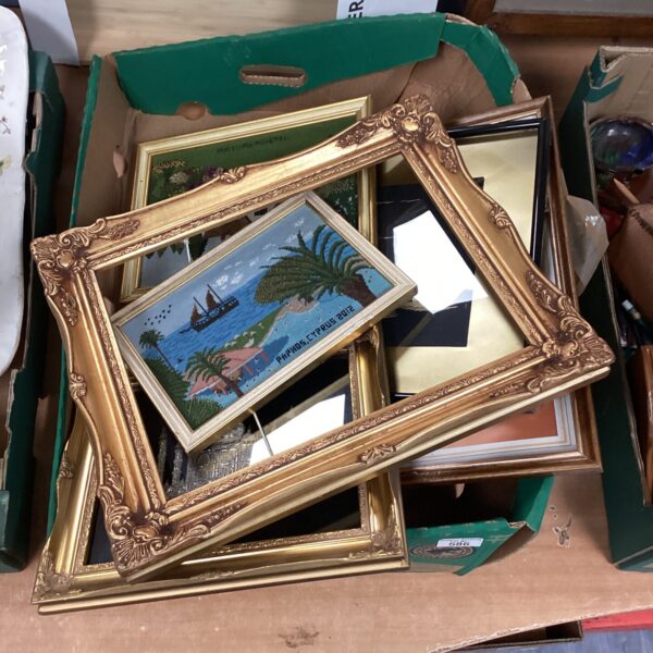 Vintage gold picture frames with prints for wall decor.