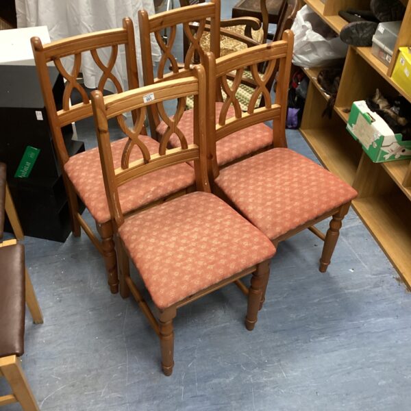 Four vintage pine dining chairs with upholstered seats.