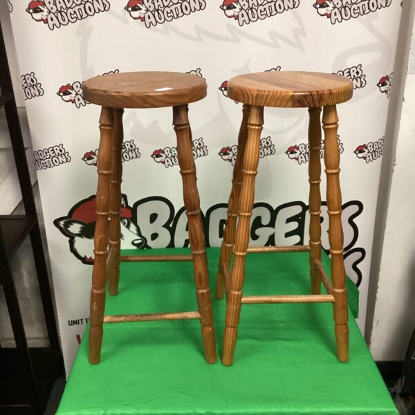 Two vintage pine kitchen stools with circular seats.