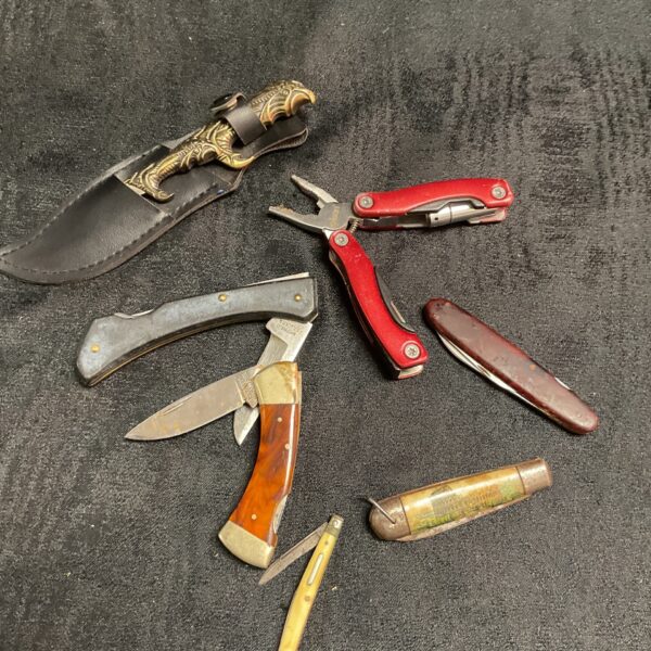Assorted vintage pocket knives with bone and red handles.