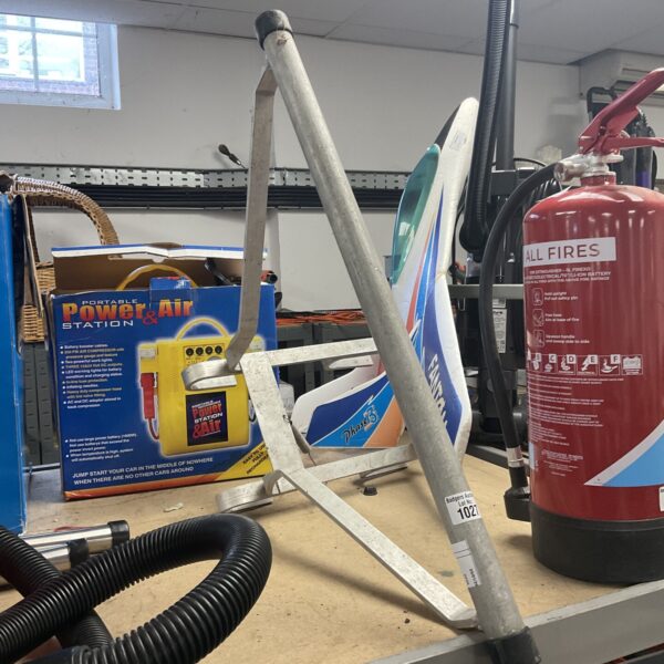 Vintage red fire extinguisher with ladder stay for fire safety.