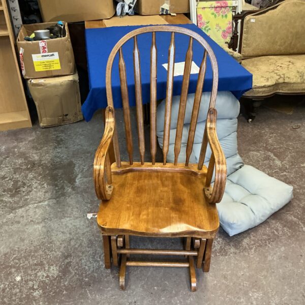 Vintage wooden rocking chair with cushioned seat for comfortable seating.