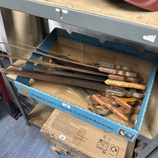Vintage saws with wooden handles in a cardboard box.
