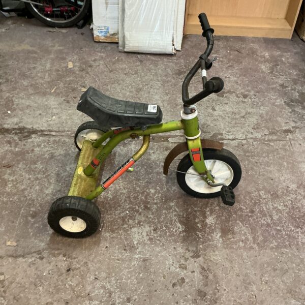 Side view of a vintage Scrambler tricycle with metal frame.