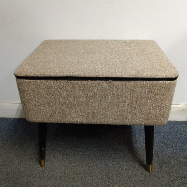 Vintage beige fabric sewing box with tapered legs.