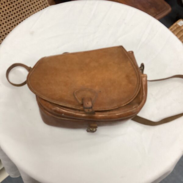 Vintage leather shooting bag with shoulder strap, ideal for collectors.