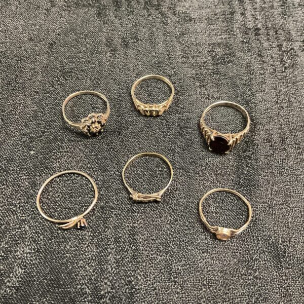 Mixed lot of vintage 925 silver rings on a dark background.
