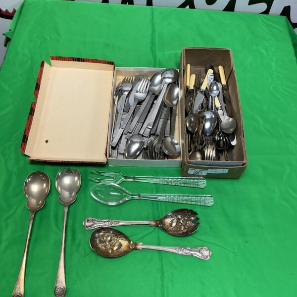 Vintage silverware set with knives, forks, and spoons displayed in a box.