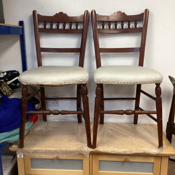 Pair of vintage spindle back dining chairs with upholstered seats.