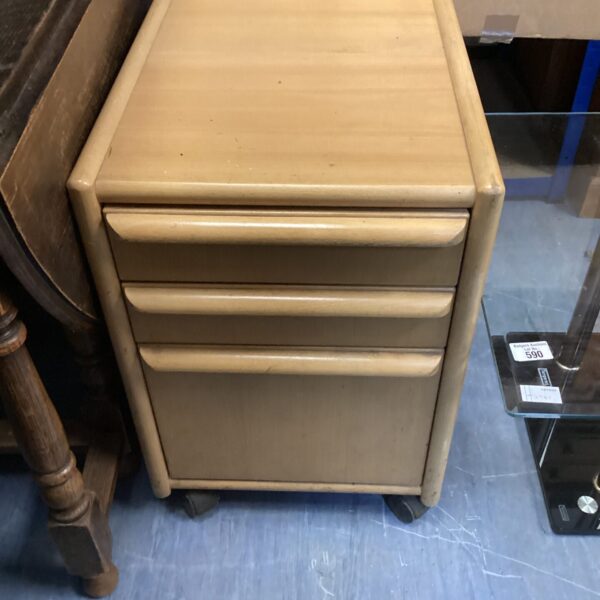 Vintage wooden three-drawer chest of drawers on wheels.