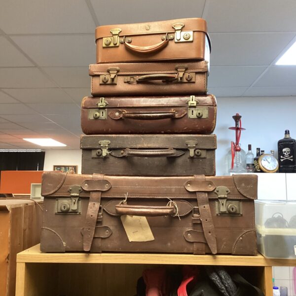 Stacked vintage travel trunks and cases, antique luggage collection.