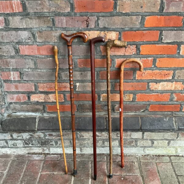 Bundle of vintage walking sticks with carved handles.