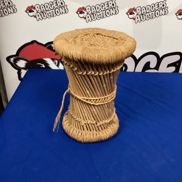 Vintage wicker plant stand for displaying plants.