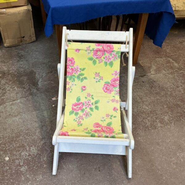 Vintage wooden deck chair with floral patterned fabric.
