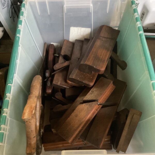 Vintage woodworking tools including planes and saws in a box.