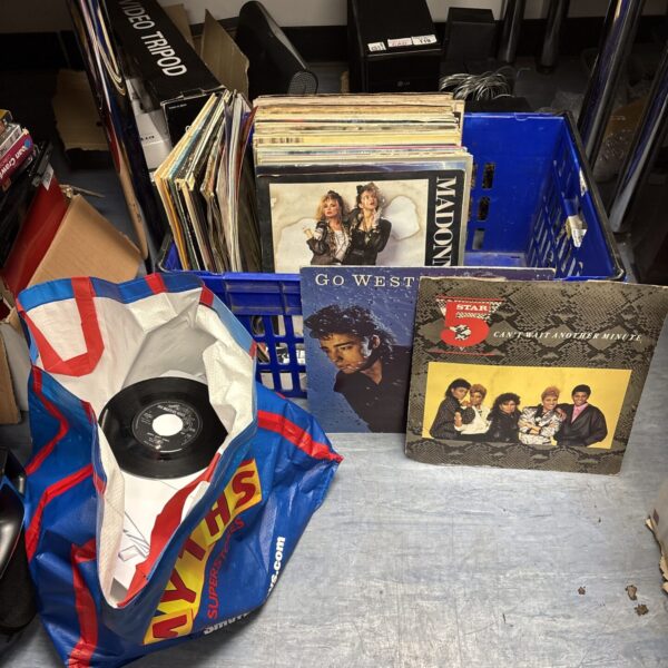 Mixed vinyl record lot in a crate, offering a diverse music collection.