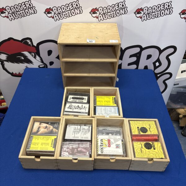 Vintage wooden storage unit filled with mixed cassette tapes.