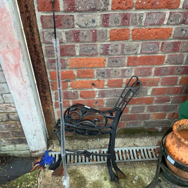 Disassembled wrought iron garden bench kit for outdoor seating.
