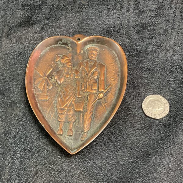 Front view of vintage WWII Dutch military bronze dish with carved figures.