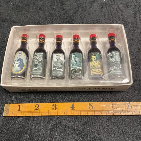 Front view of WWII miniature bottles and cans set in display box.