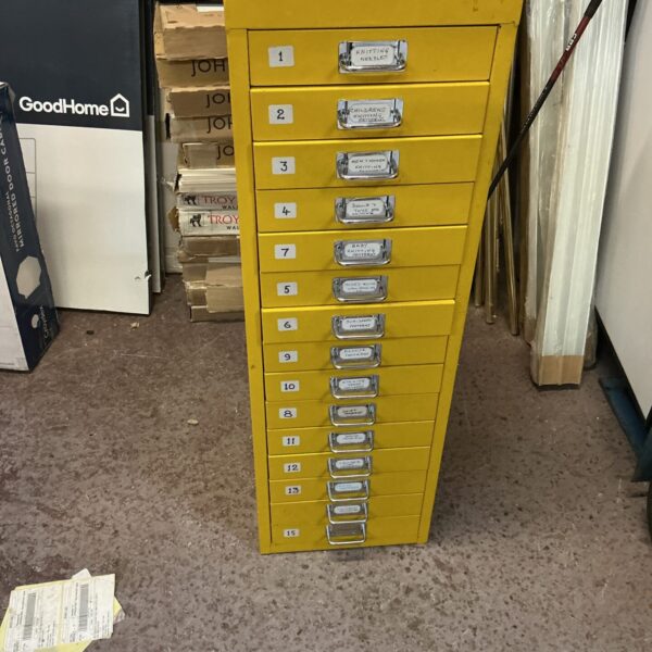 Vintage yellow metal filing cabinet with drawers for office storage.