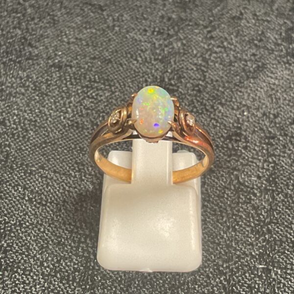 Close-up of a 14ct rose gold opal ring with diamond accents.