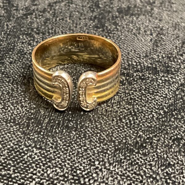 Elegant 18k tri-colour gold ring with diamond set motifs.