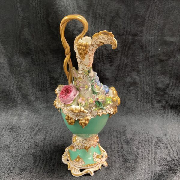 Antique 19th-century porcelain ewer with flower encrusted decoration.