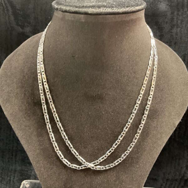 Two 925 silver Figaro chain necklaces on a display stand.