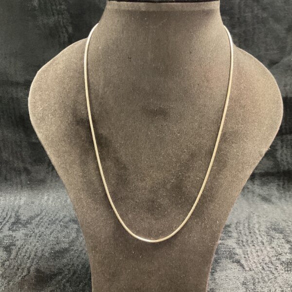 Delicate 925 silver snake chain necklace on a display stand.
