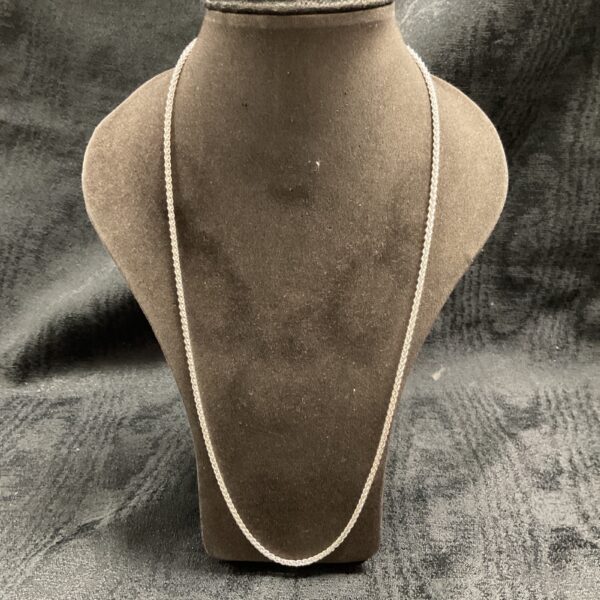 Close-up of a 925 silver snake link necklace on a display stand.