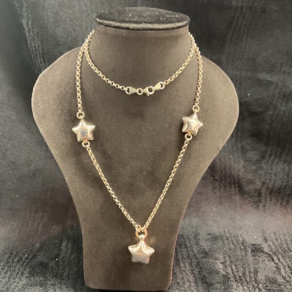 Delicate 925 silver star necklace on a display bust.