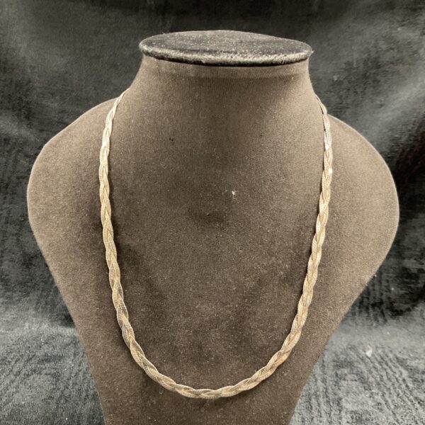 Close-up of 925 silver weaved necklace on a display stand.