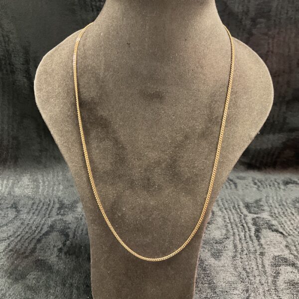 Delicate 9ct yellow gold chain necklace on a display.