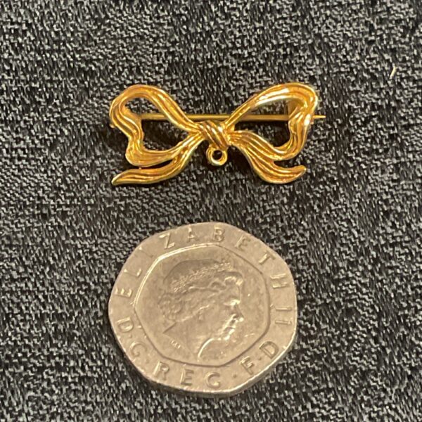 Delicate 9ct gold ribbon brooch with a classic bow design.