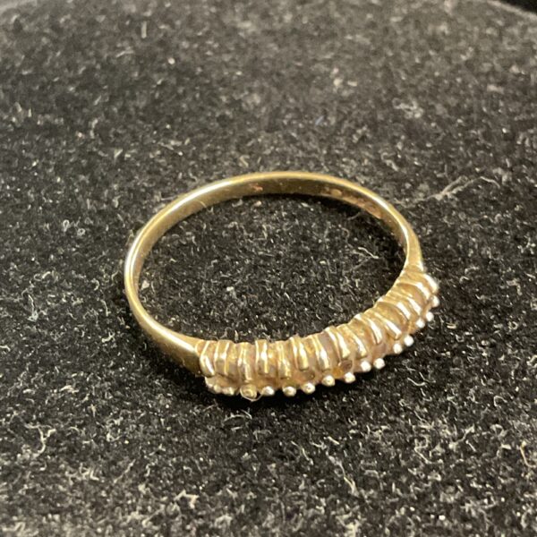 Delicate 9ct gold ring with seven white stones.