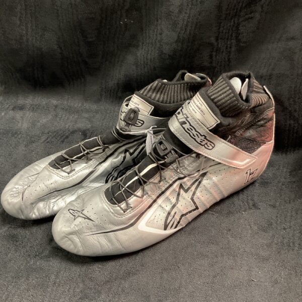 Silver Alpinestars racing boots, size 44, showing wear.