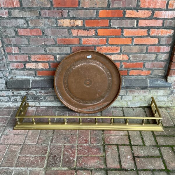 Antique brass fireplace fender and large Persian copper charger tray.
