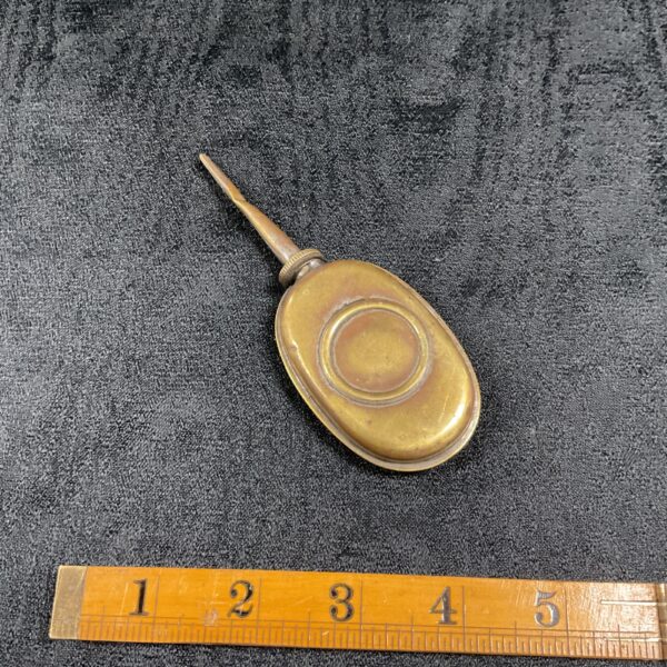 Antique brass oil can with slender spout, vintage tool.