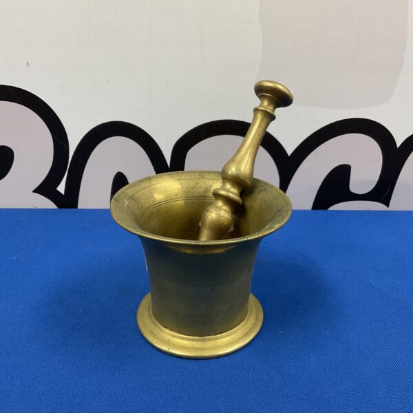 Antique brass pestle and mortar set for grinding spices.