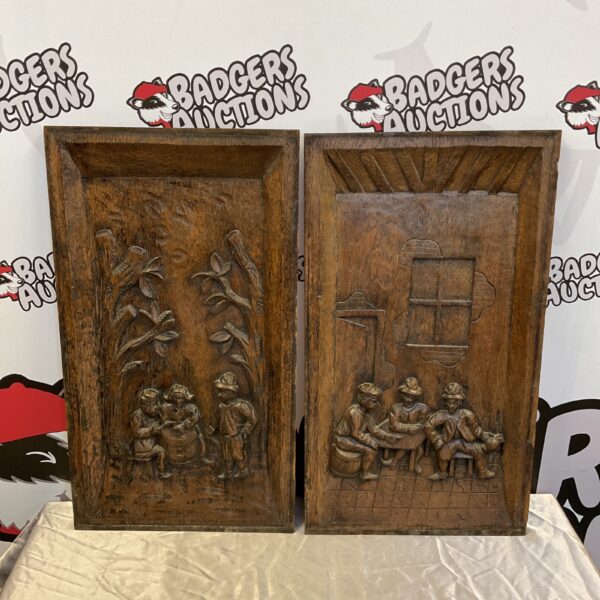 Antique carved oak tavern panels depicting a lively pub scene.