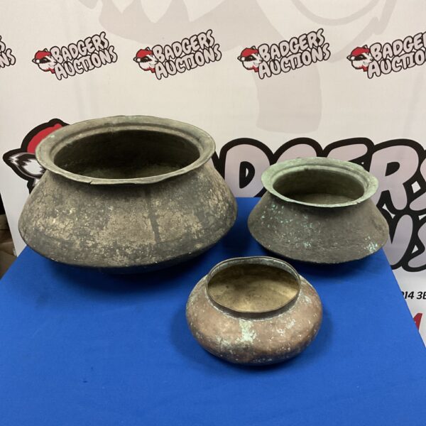 Set of three antique copper pots with patina.