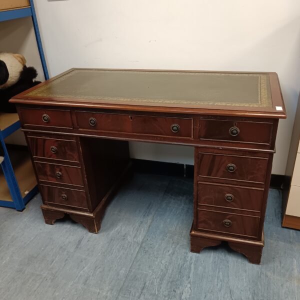 Antique mahogany executive desk with green leather top.
