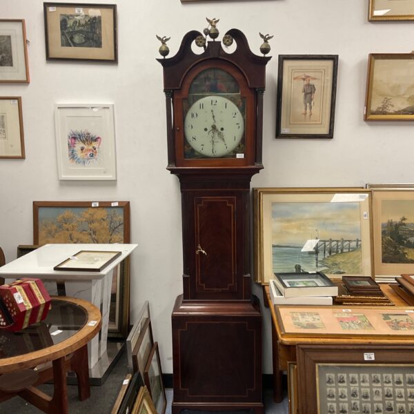 Antique grandfather clock with a hand-painted classical scene on the face.