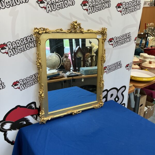Ornate antique guilded mirror with detailed frame.
