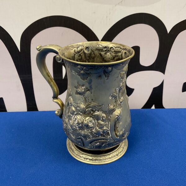 Antique Harvey & Co pewter tankard with embossed floral design.