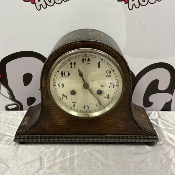 Front view of antique Napoleon hat mantle clock with wooden case.